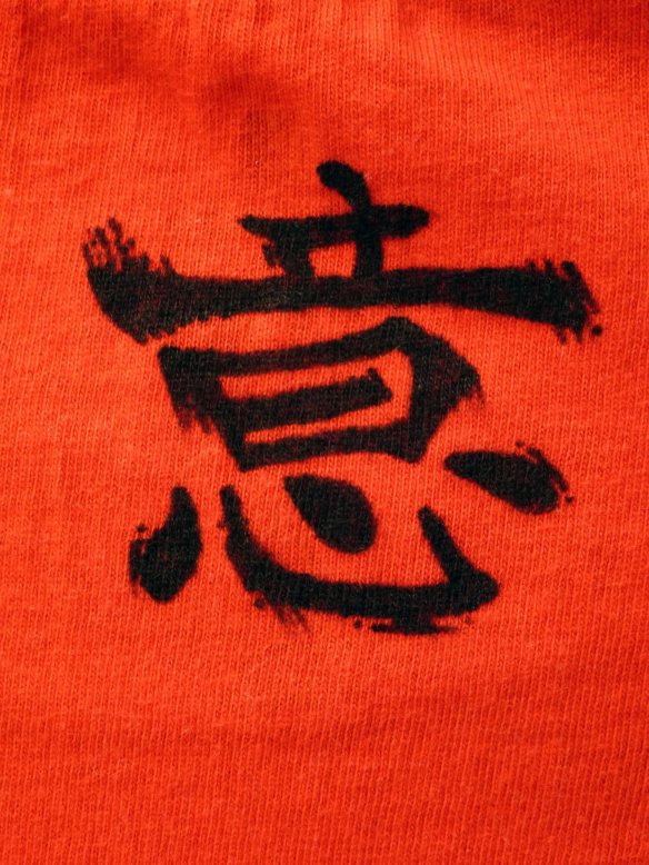 Sur la nuque, l'idégramme chinois du "Yi" signifiant "l'intention".